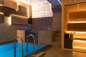 a bathroom with a swimming pool and a fireplace at Sunny apartment in Niš