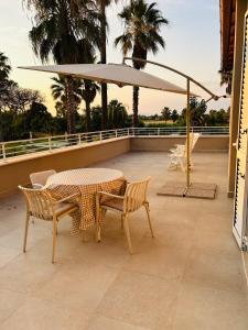 a table and chairs and an umbrella on a balcony at Serenity House Latina in Latina