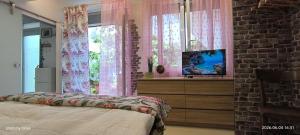 a bedroom with a bed and a tv on a dresser at Apartma REA Izola, pergola & terassa, parking in Izola