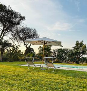 two chairs and an umbrella next to a pool at Serenity House Latina in Latina