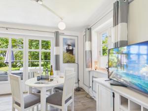 a dining room with a white table and a flat screen tv at Ferienwohnung Goting in Goting