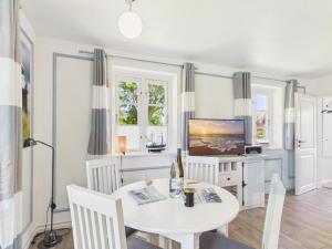 a dining room with a white table and chairs and a tv at Ferienwohnung Goting in Goting +17 photos