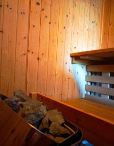 a tub filled with rocks next to a wooden wall at Private wellness with panoramic view, sauna & jacuzzi in Maribor