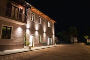 a building with a bench on the side of it at night at Fermata Sessant in Asti