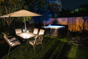 a table and chairs with an umbrella and a hot tub at Fermata Sessant in Asti