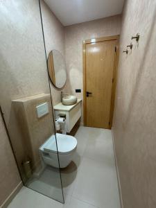 a bathroom with a toilet and a sink and a mirror at Belle cote appartement al hoceima in Al Hoceïma +48 photos
