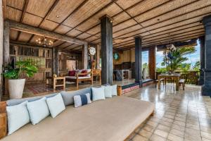 a living room with a couch in the middle at The Joglo at Umah Sunset in Ubud