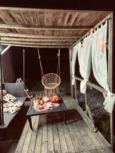 a wooden deck with a table and a swing at Le Noble Jardin in Mohon