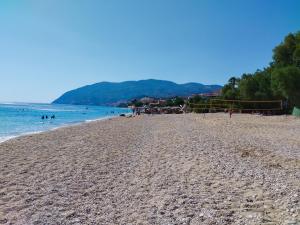 a sandy beach with people in the water at Orange Grove in Plomari