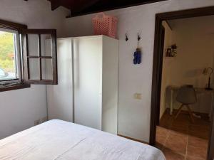 a bedroom with a white bed and a window at Finca Nim 1 in Mogán