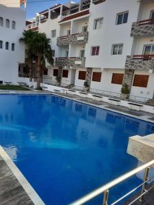 a large blue swimming pool in front of a building at Amsa Tetouan in Chozas
