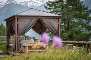 a gazebo with a bed in a field at Naturlodge Gadestatt in Loch +35 photos
