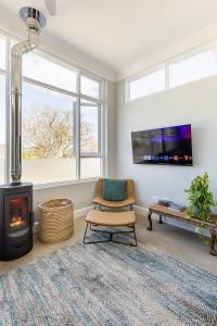 a living room with a chair and a fireplace at Lagoon View Cottage in Knysna