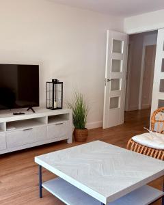 a living room with a tv and a table at Canto de la Perdiz in Villafranca del Bierzo