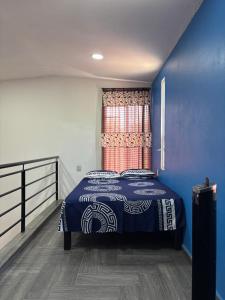 a bedroom with a bed with a blue wall at Tiny House Molino Alto in Ciudad Fernández