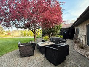 a patio with wicker chairs and a table under a tree at TnTBnB in Combined Locks