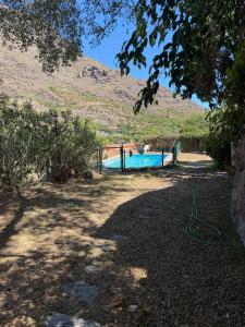 a boat in a yard with a hill in the background at Finca Nim 1 in Mogán