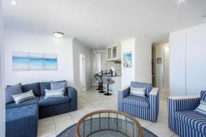 a living room with a blue couch and chairs at Hibernian Towers 408 in Strand
