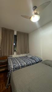 a bedroom with a bed and a ceiling fan at Quarto privativo confortável próximo a ufba, praia, comercio e zoológico in Salvador