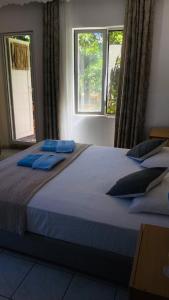 a large bed in a bedroom with two windows at Rosemary Kütle pansiyon in Cıralı
