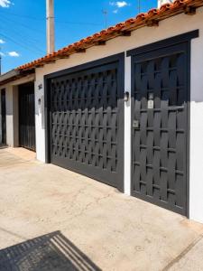 a garage with a black garage door and a building at Apartamentos-6-3-8 - Pousada Itapetininga in Itapetininga