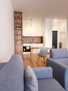 a living room with two blue couches and a kitchen at Apartment 22 - calm location in Bar