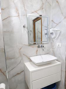 a bathroom with a white sink and a mirror at Aparthotel Fitimi in Borsh +95 photos