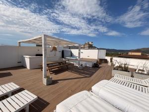 a rooftop deck with white furniture and a canopy at Appartement- rooftop à Rosas in Roses