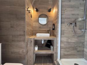 ein Badezimmer mit Dusche und Waschbecken in der Unterkunft Angleterre Hotel in Paris