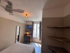 ein Schlafzimmer mit Bett und Deckenventilator in der Unterkunft Angleterre Hotel in Paris + 45 Fotos