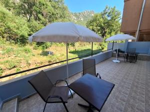 a patio with a table and chairs and an umbrella at Canj Cozy apartment - Studio in Čanj