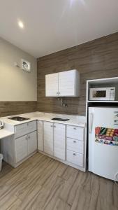 a kitchen with white cabinets and a white refrigerator at منتجع وفلل المرفأ ابها in Abha