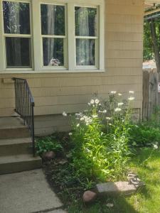a house with a flower garden in front of it at Plantlife LLC Lodge U room in Minneapolis