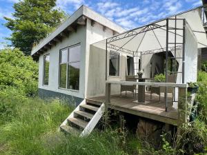 a small house with a porch and a wooden deck at foresthaus in Glücksburg
