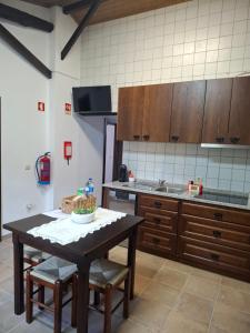 a kitchen with a table and chairs in a room at Cantinho do Lello in Bragança +6 photos