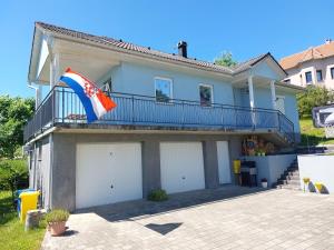 a house with a flag on a balcony at Juraj apartman studio in Brdovec