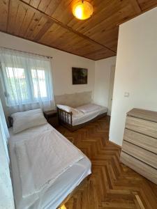 a bedroom with two beds and a wooden ceiling at Emília apartman in Balatonszemes