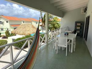 a balcony with a hammock and a table and chairs at Lagoon Ocean Resort 2 bdrm/2bath with beach access in Lagun