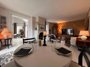 a living room with a white table with chairs and a couch at La petite duchesse - jaccuzzi in Plérin