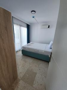 a bedroom with a bed in a room with a window at Ilya Apart 1 in Bodrum City