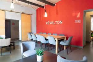 a conference room with a red wall and a table and chairs at Revelton Ostrava in Ostrava