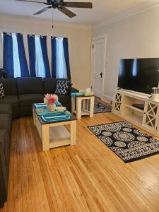 a living room with a couch and a flat screen tv at Plantlife LLC Lodge U room in Minneapolis
