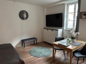 a living room with a table and a tv at Herzstück in Ansbach