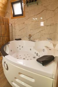 eine weiße Badewanne in einem Badezimmer mit Fenster in der Unterkunft Vila Markizo in Barajevo + 21 Fotos