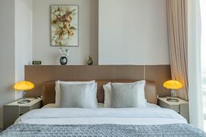 a bedroom with a large bed with two lamps at Luxurious Studio Marina View Condor Marina Star in Dubai +29 photos