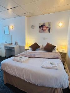 a bedroom with a large bed with towels on it at The Jack Sparrow Hotel in Blackpool