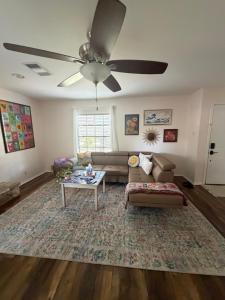 a living room with a couch and a ceiling fan at Peaceful cottage in San Antonio