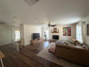 a living room with a couch and a flat screen tv at Peaceful cottage in San Antonio