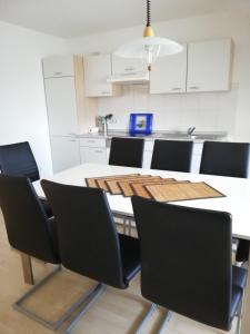 a kitchen with a table and black chairs in a room at Ferienwohnung am Bodensee mit 3 Schlafzimmer über 2 Etage mit kleine Balkon bis 6 Personen in Überlingen