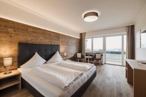 a bedroom with a large bed with a wooden wall at Hotel Greifenstein in Terlano